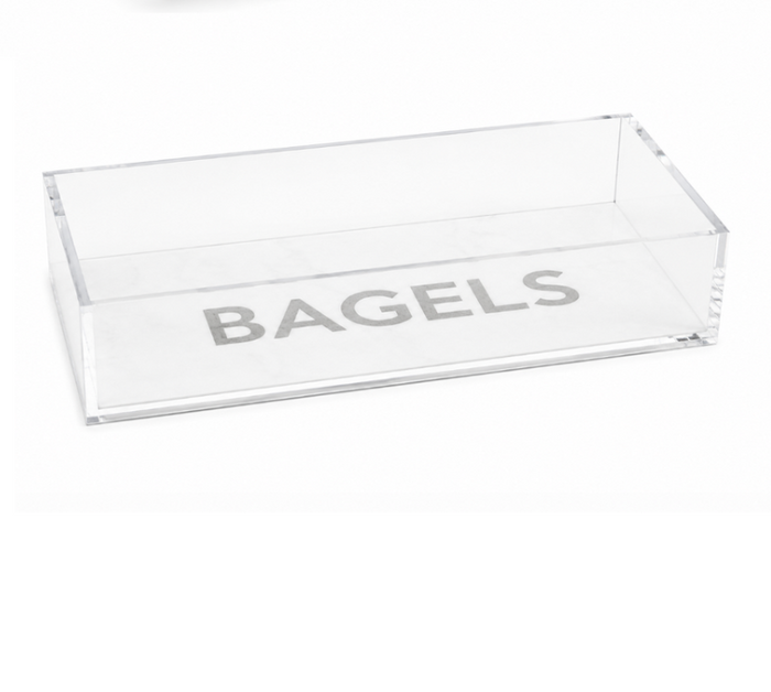Introducing the Eye Candy Bagel Tray: a clear, rectangular acrylic container featuring the word “BAGELS” in bold gray letters on the bottom. This food-safe tray from Eye Candy makes an ideal gift for any bagel lover.