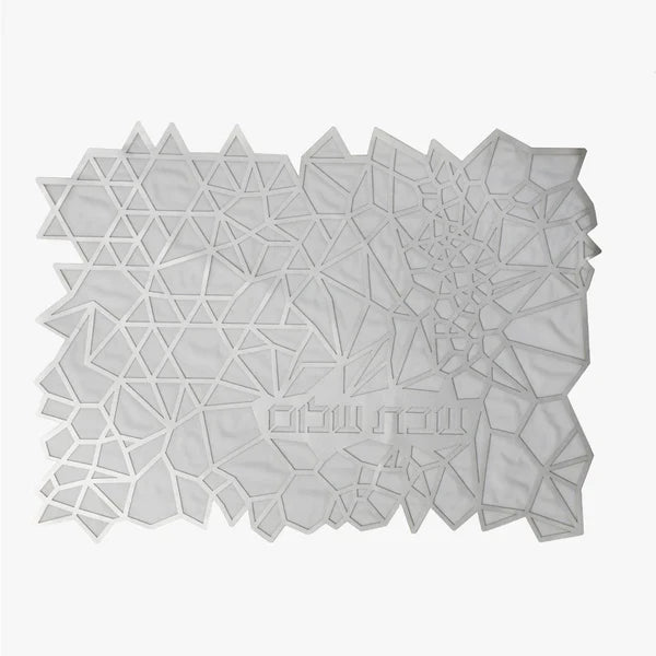 The Geometric Challah Cover by Apeloig is a modern white cover with an abstract pattern of polygons and triangles, featuring Hebrew text on the lower right.