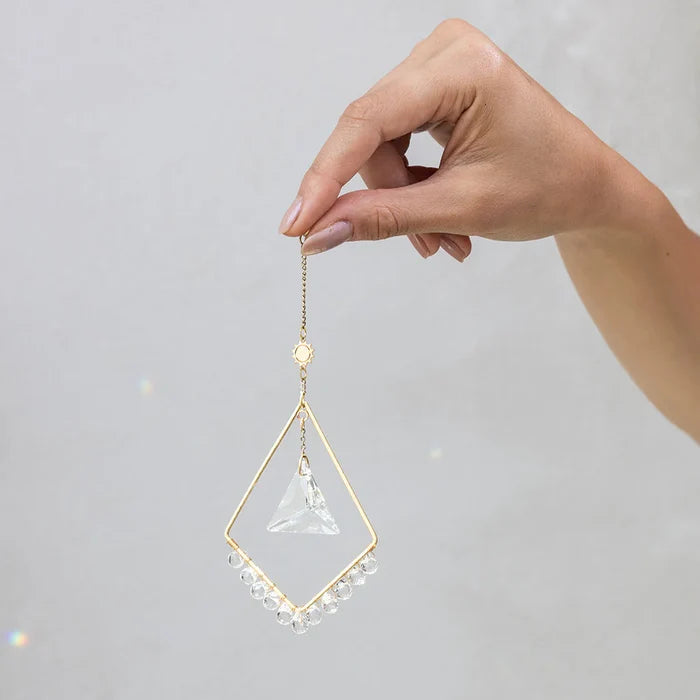 Scout Curated Wears Sun Harmony mini crystal suncatcher featuring gold-plated brass frame and crystal prism creating rainbow reflections